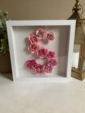 White shadow box with pink floral letter 'S' and name 'Sasha' on a neutral background