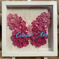 Butterfly-shaped art made of pink roses with 'Celeste & Ava' in the center, framed in white.