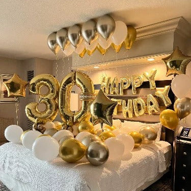 Decorated room with 'Happy 30th Birthday' balloons and gold streamers.