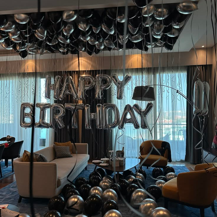 Luxury black and chrome silver helium ceiling balloon decoration for birthday surprise setup in Dubai hotel apartment