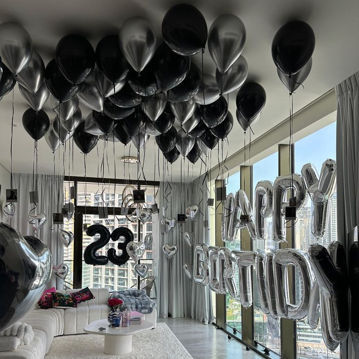 Luxury black and chrome silver helium ceiling balloon decoration for birthday surprise setup in Dubai hotel apartment