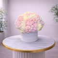 Pastel-colored bouquet in a white box on a marble table with a blurred background